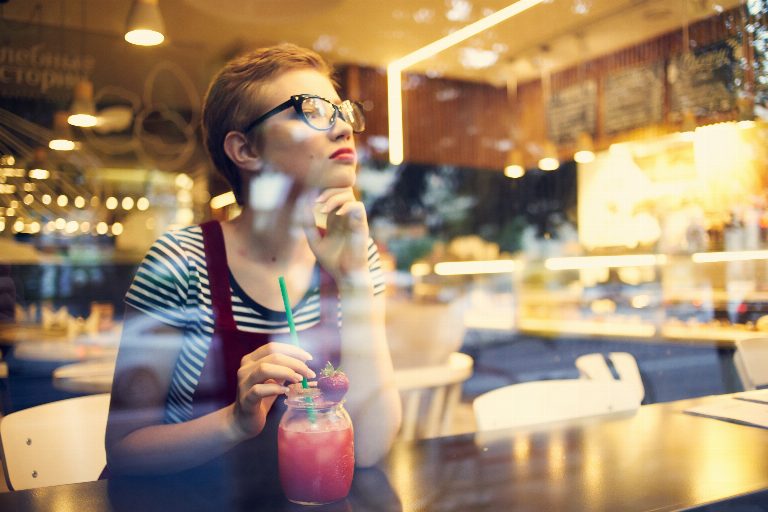 woman sitting in a restaurant with a cocktail loneliness pensive look. High quality photo